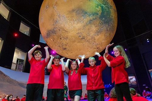 Group of school kids holding up mars