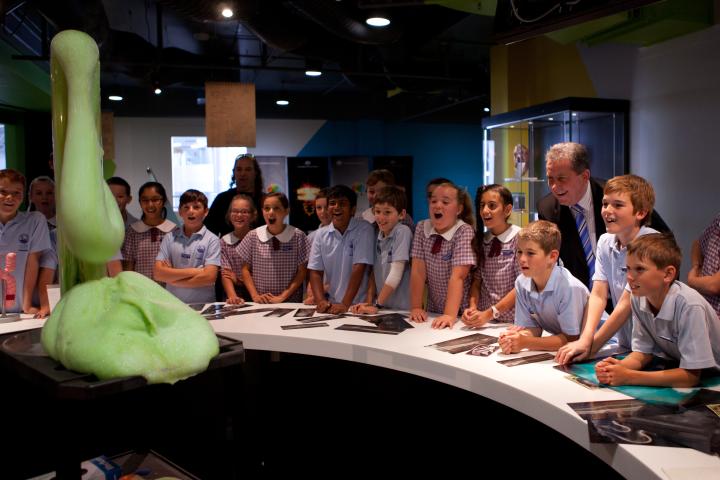 Group of school students watching an explosion of green foam