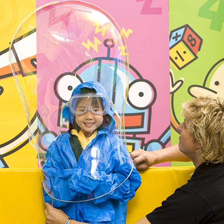 A Science Squad presenter encases a child in a bubble