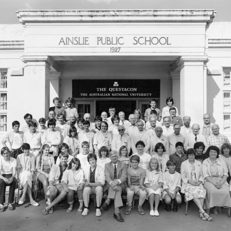 Questacon staff seated in front of Ainslie Public School, 1980