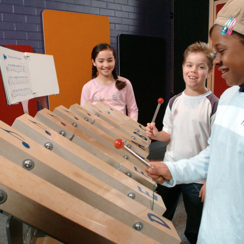 Children play a giant xylophone